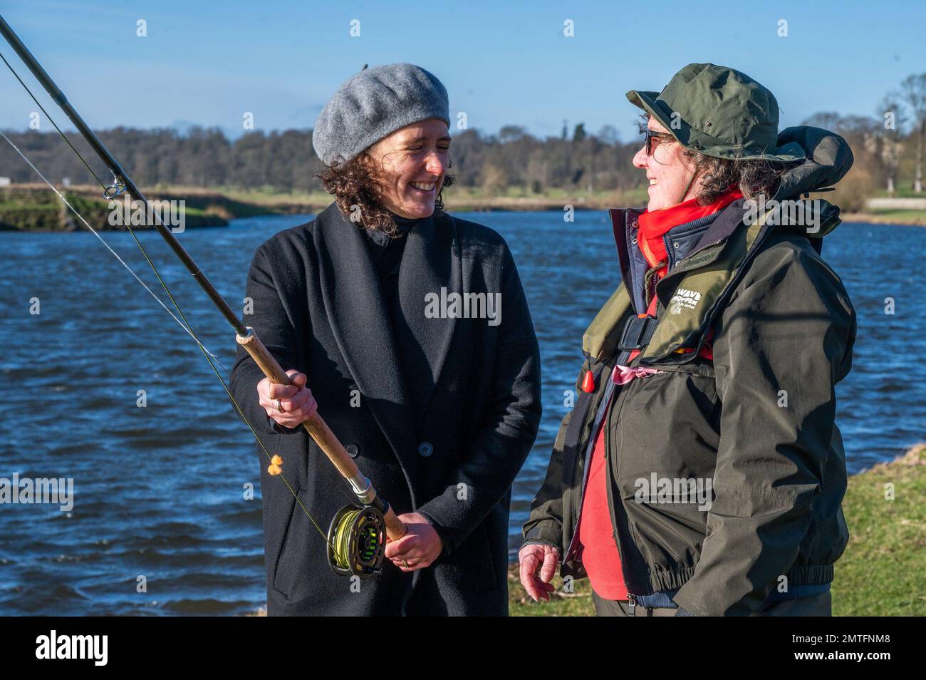 . Kelso, River Tweed, Scottish Borders, Scotland, UK. Apertura ufficiale della stagione di pesca del salmone del fiume Tweed 2023. Si tiene a Kelso, ai confini scozzesi. Mairi Gougeon MSP, segretario del governo scozzese per gli affari rurali e le isole si unisce al pescatore Sam Mutters in occasione dell'apertura ufficiale della stagione di pesca del salmone del fiume 2023. Il Tweed è il fiume di salmone più produttivo del Regno Unito, attirando pescatori da tutto il mondo e contribuendo ogni anno a circa £24 milioni di dollari all'economia locale. Comunicato stampa 1 Febbraio 2023 River Tweed Salmon Fishing Season Offi Foto Stock