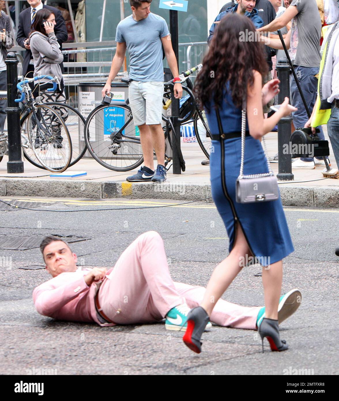 Indossando una tuta rosa con le sneaker Nike baby blue, Robbie Williams e  la star Skins Kaya Scodelario sono stati avvistati su scene di set per il  suo nuovo video musicale a