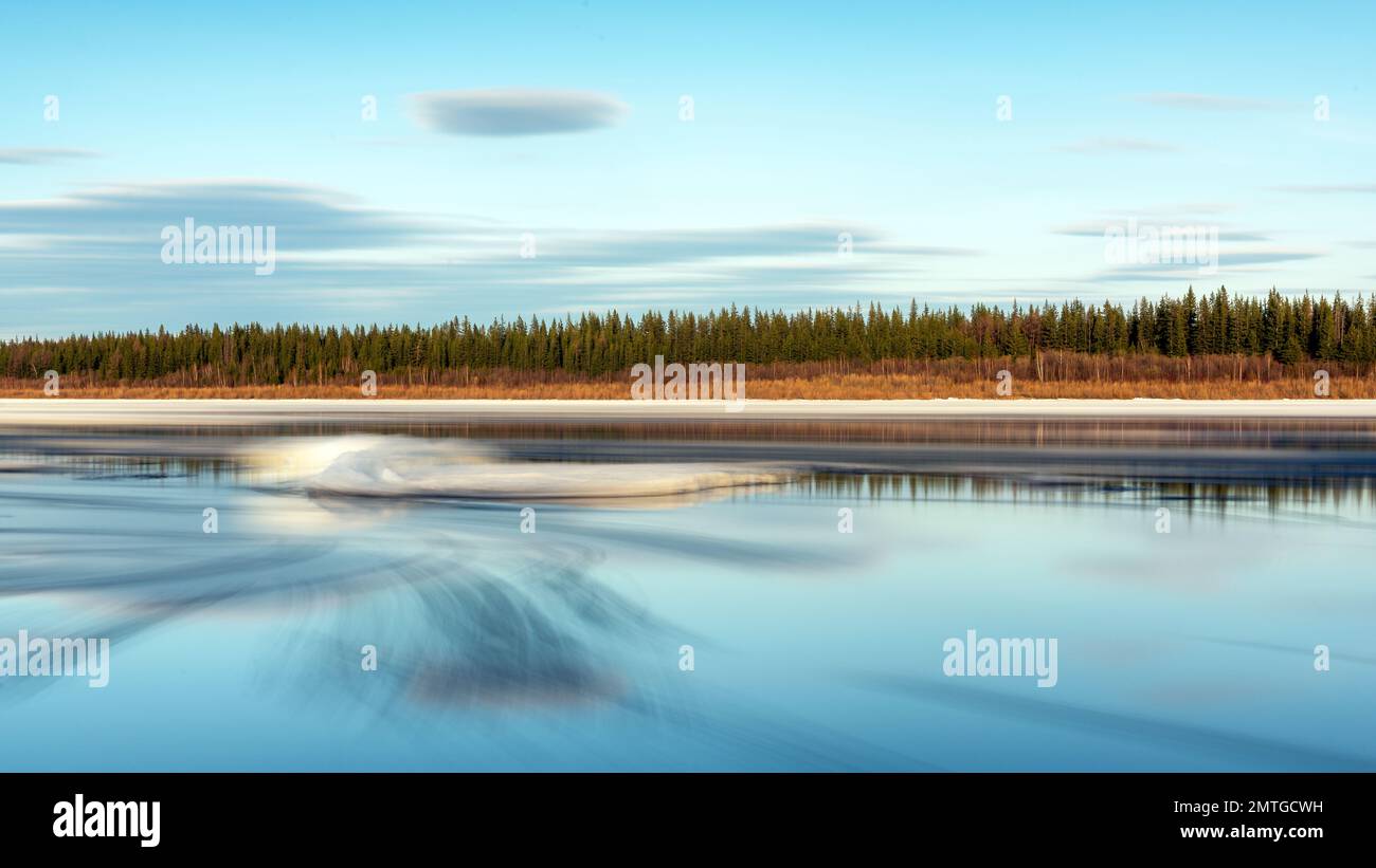 Il ghiaccio di primavera si scioglie sullo sfondo del movimento del flusso d'acqua con ghiaccio sulla deriva di ghiaccio del fiume Vilyui a Yakutia. Esposizione lunga. Foto Stock