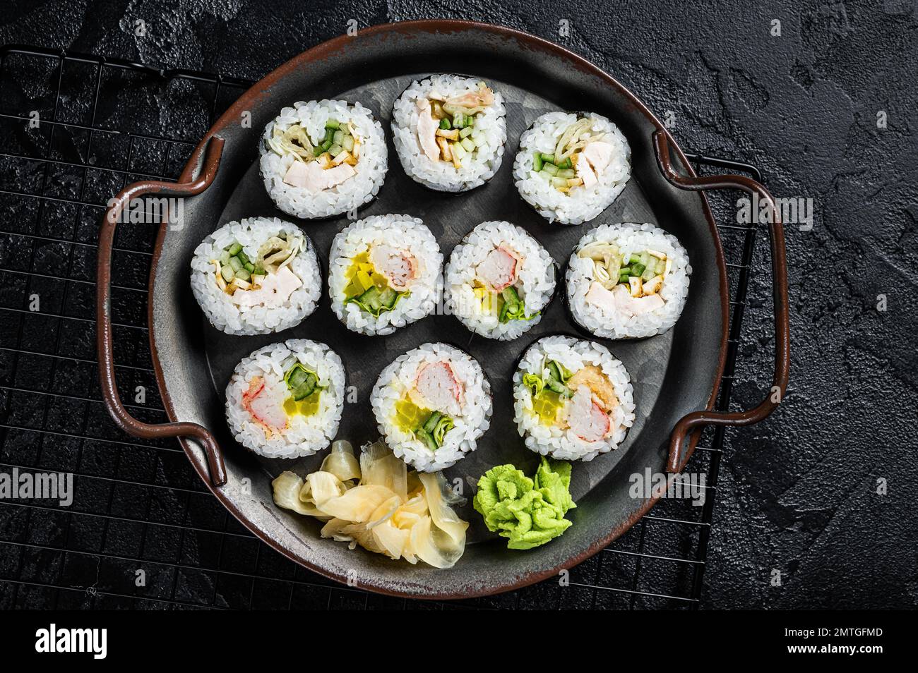 Gimbap Kimbap ripieno di verdure, uova, acciughe e granchio, rotolo di riso coreano. Sfondo nero. Vista dall'alto. Foto Stock