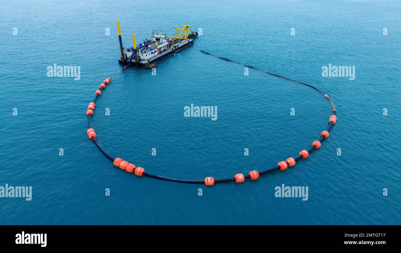 Barriera flottante del braccio utilizzata per contenere una fuoriuscita di olio. Un'imbarcazione offshore che esegue l'esercizio di risposta alle fuoriuscite di petrolio in mare. Foto Stock