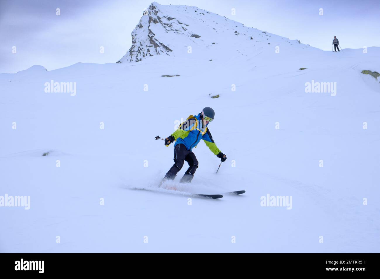 Due uomini che sciano in discesa nelle Alpi svizzere Foto Stock