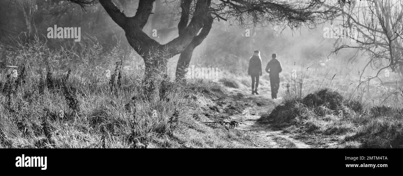 Panoramica monocromatica di due escursionisti sulla Sutton Bank in nebbia, North Yorkshire Moors, Inghilterra Foto Stock