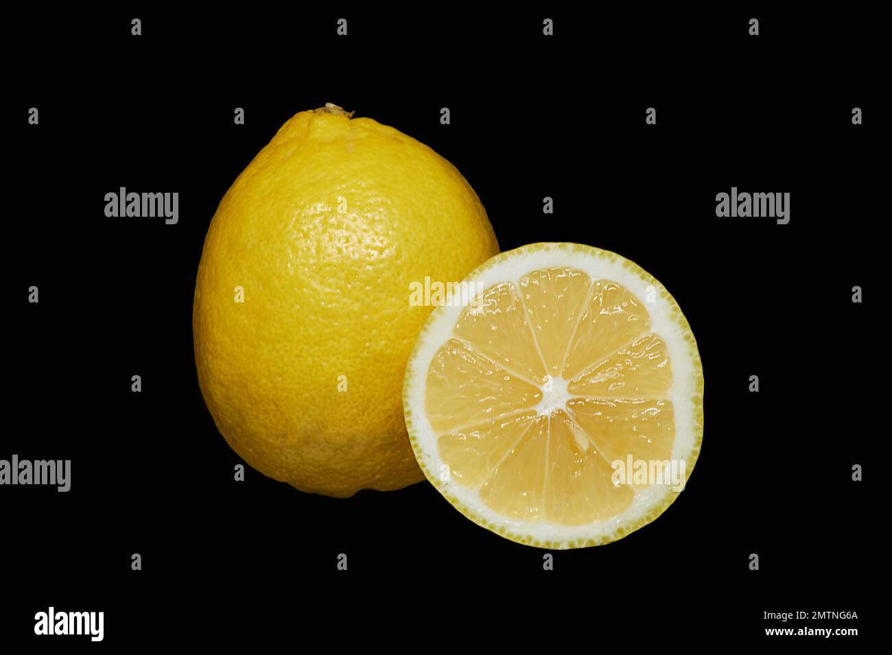 Immagine di un limone maturo e di una parte tagliata su sfondo nero Foto Stock