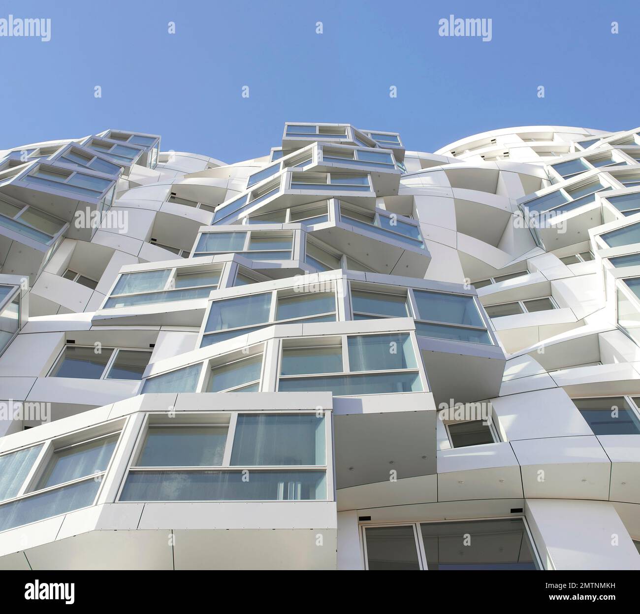 Guardando verso il cielo lungo la facciata bianca increspata. Prospect Place Battersea Power Station Frank Gehry, Londra, Regno Unito. Architetto: Frank Gehry, 2022 Foto Stock