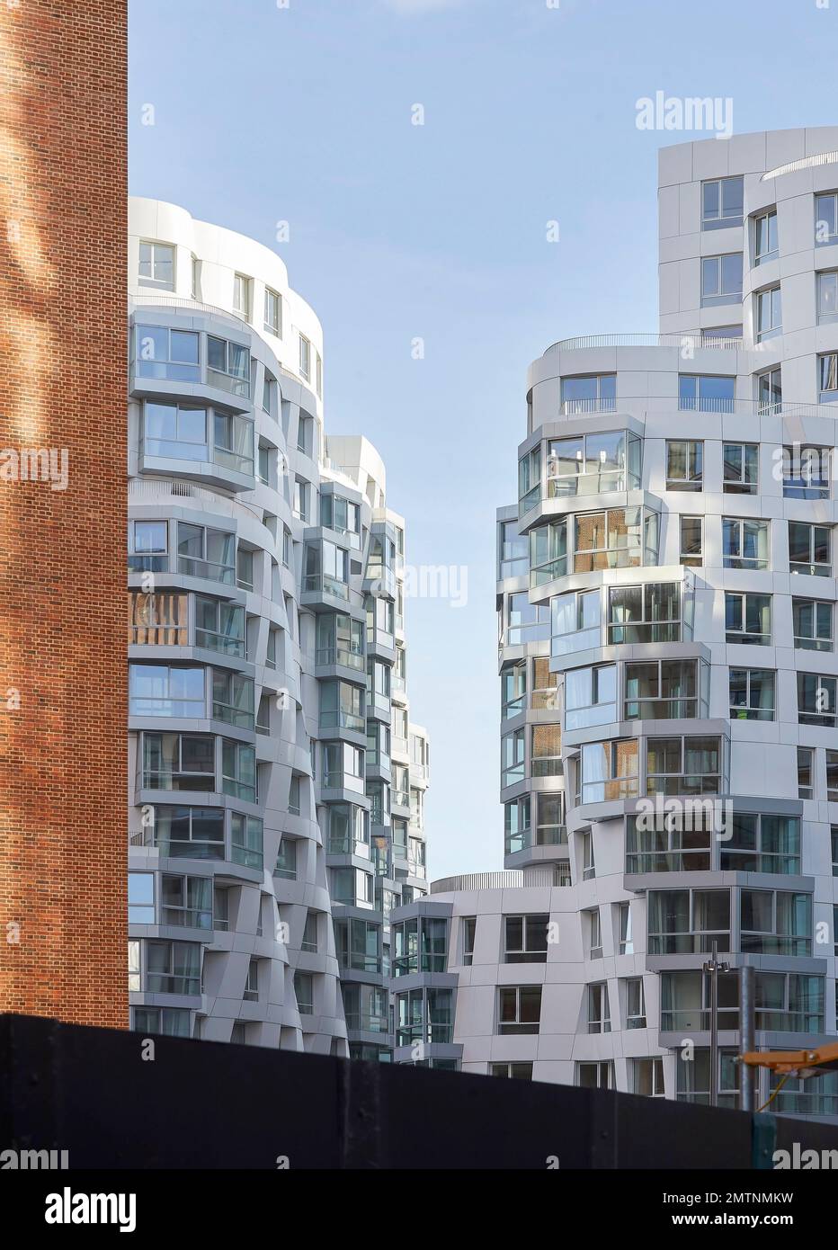 Mattoni rossi giustapposti alla facciata bianca increspata di Prospect Place. Prospect Place Battersea Power Station Frank Gehry, Londra, Regno Unito. Arche Foto Stock
