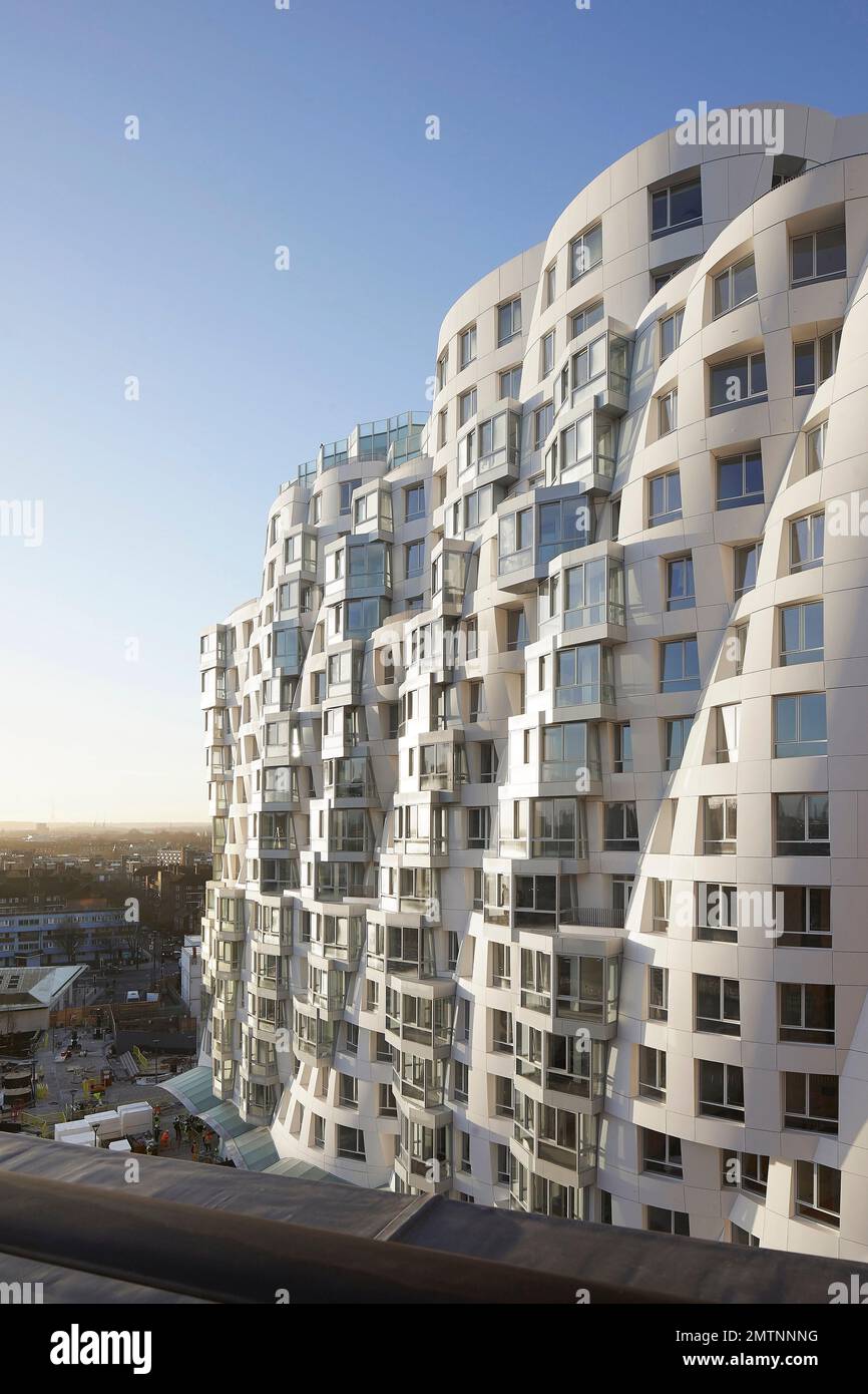 Prospettiva della facciata con estensione urbana oltre. Prospect Place Battersea Power Station Frank Gehry, Londra, Regno Unito. Architetto: Frank Gehry, 2022. Foto Stock