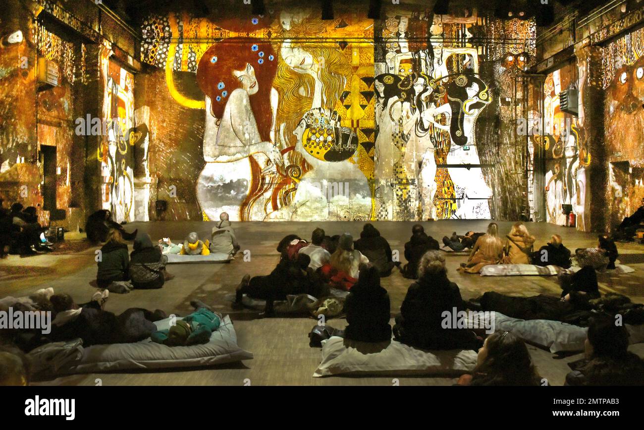 29 gennaio 2023, Sassonia, Lipsia: Nella Kunstkraftwerk, un ex impianto di cogenerazione, i visitatori guardano l'installazione multimediale Gustav Klimt - GoldExperience, in cui sono proiettati nello spazio molti dipinti famosi. Nella mostra dell'italiano Stefano Fake e della sua fabbrica di Fake, le stazioni e le opere dell'artista austriaco Gustav Klimt (1862-1918), uno dei più importanti rappresentanti dell'Art Nouveau viennese, sono esposte in varie aree tematiche come una proiezione monumentale in tutta la sala e sul pavimento. Lo spettacolo sarà in vista fino al 28 maggio 2023. Foto: Waltraud Gruditzsch/dpa - ATTENZIONE: Foto Stock