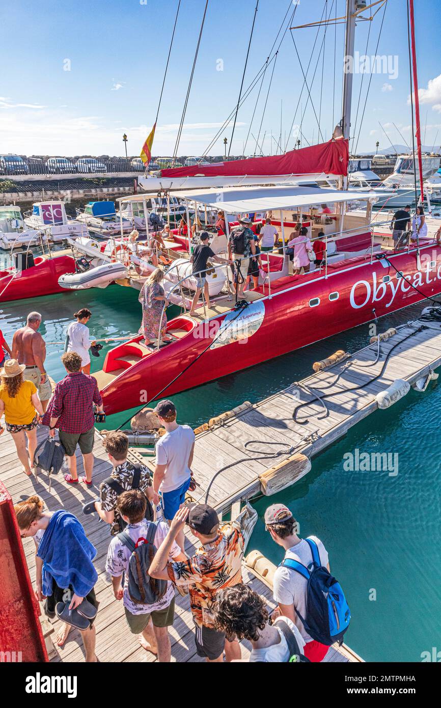 I turisti che si imbarchano sul catamarano Obycat Experience nel porto di Caleta de Fuste, sulla costa orientale dell'isola delle Canarie di Fuerteventura, Spagna Foto Stock