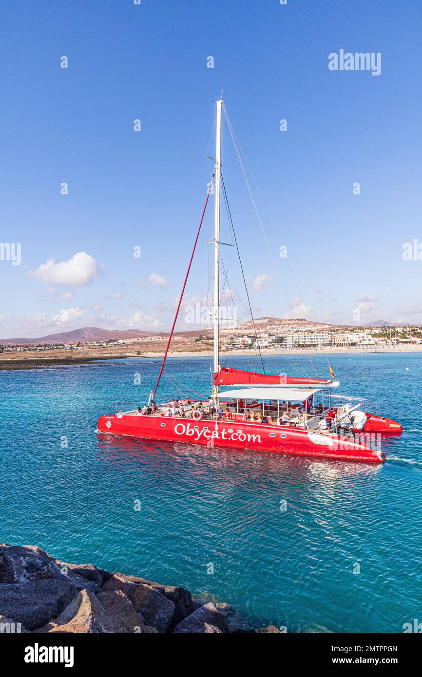 I turisti a bordo del catamarano Obycat Experience lasciano il porto di Caleta de Fuste sulla costa orientale dell'isola delle Canarie di Fuerteventura, Spagna Foto Stock