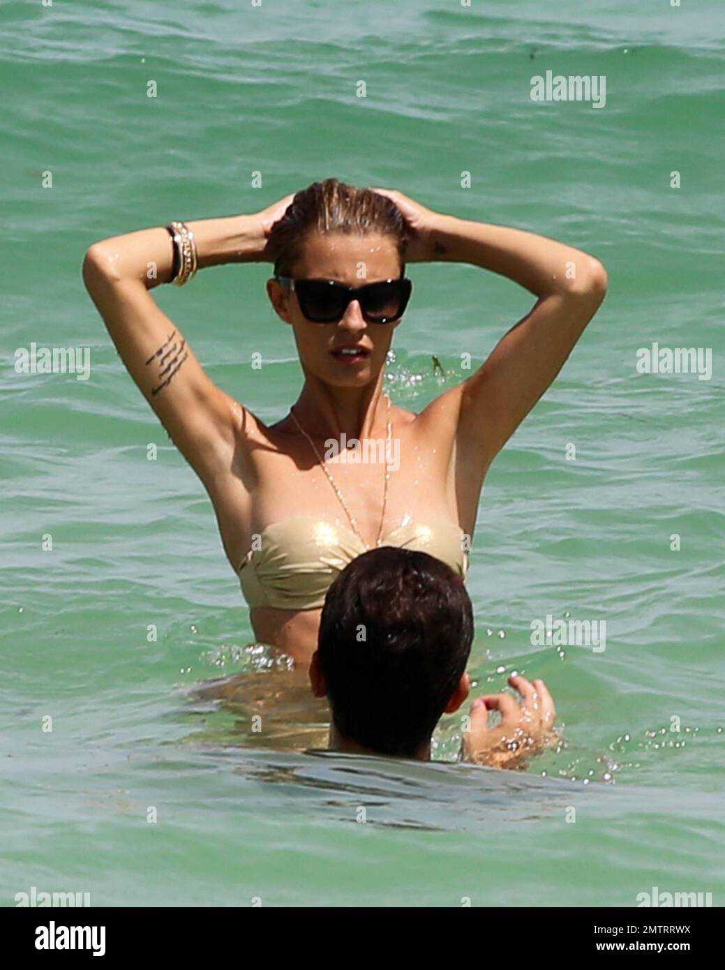 Sveva Alviti indossa un bikini verde e oro non corrispondente che mostra il suo tatuaggio pelvico e la sua sottile cornice. Miami Beach, Florida. 16th agosto 2014. Foto Stock