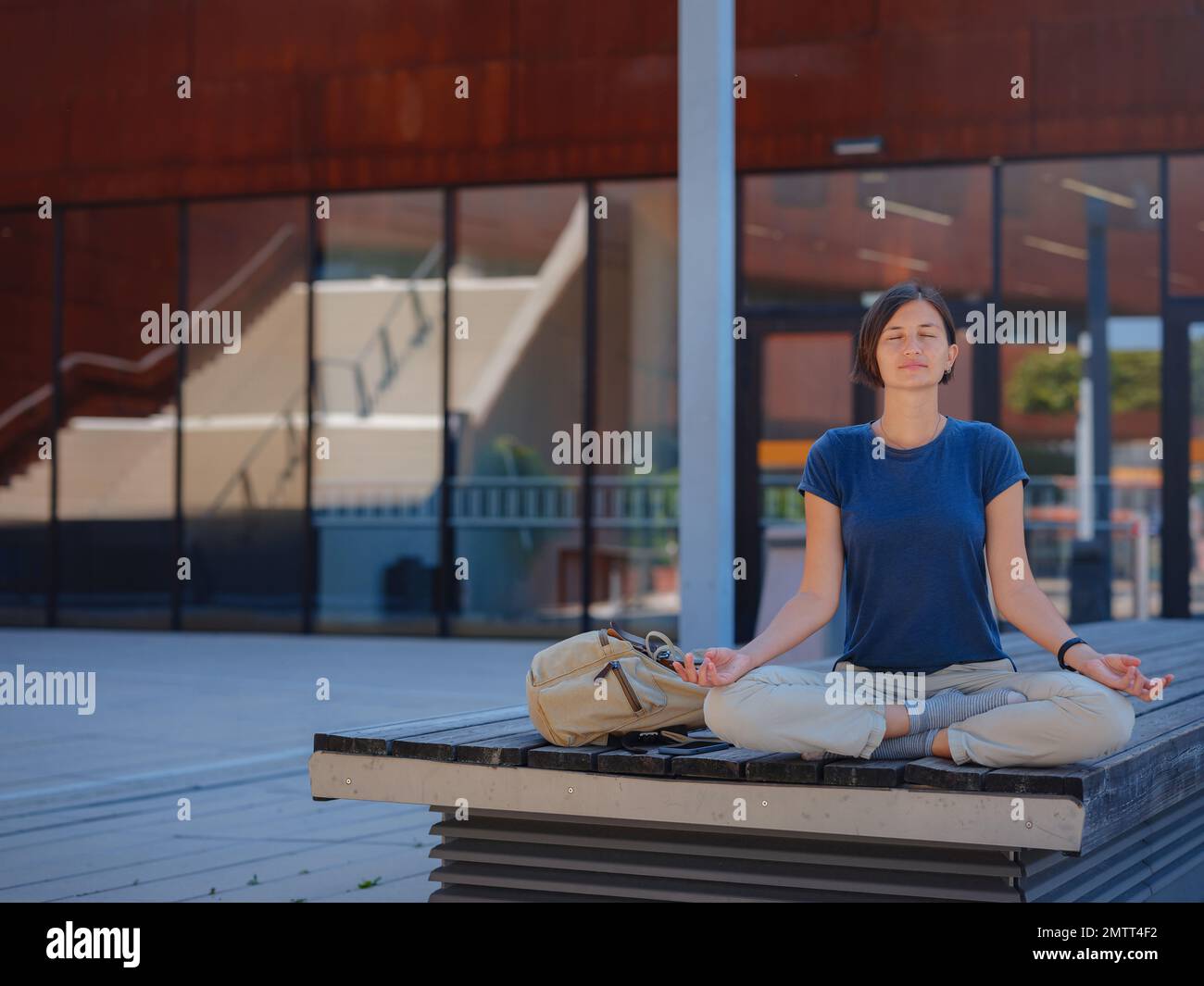 Allegra studentessa asiatica in piedi all'aperto, felice giovane donna orientale che cammina nel campus dell'Università di Economia di Vienna, pausa dopo lezione, riposa un Foto Stock