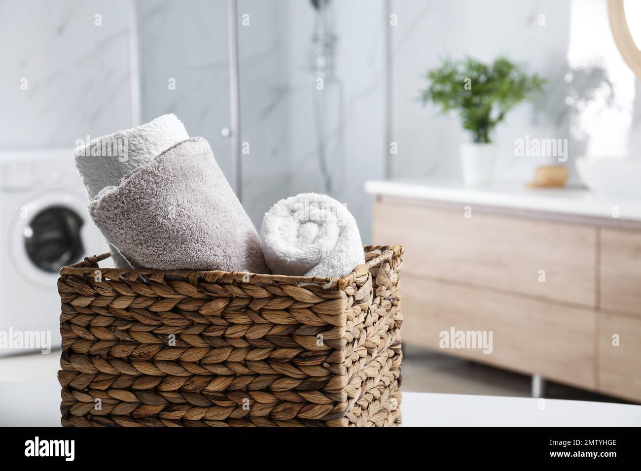 Cestino in vimini con asciugamani puliti e morbidi in bagno. Spazio per il  testo Foto stock - Alamy