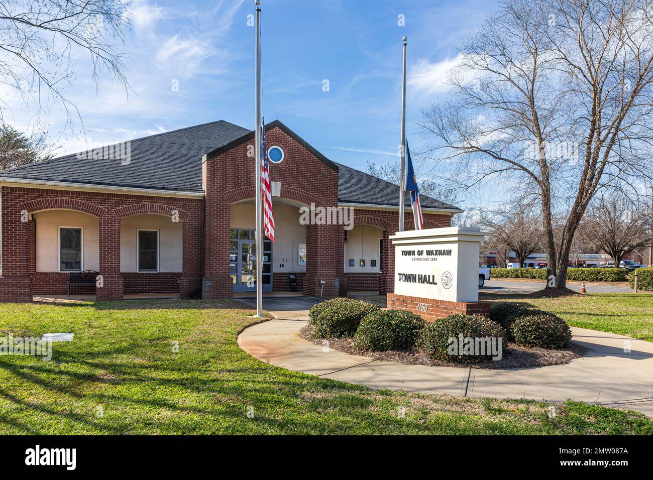 WAXHAW, NC, USA-28 GEN 2023: Municipio, edificio, cartello monumento, pali della bandiera Foto Stock