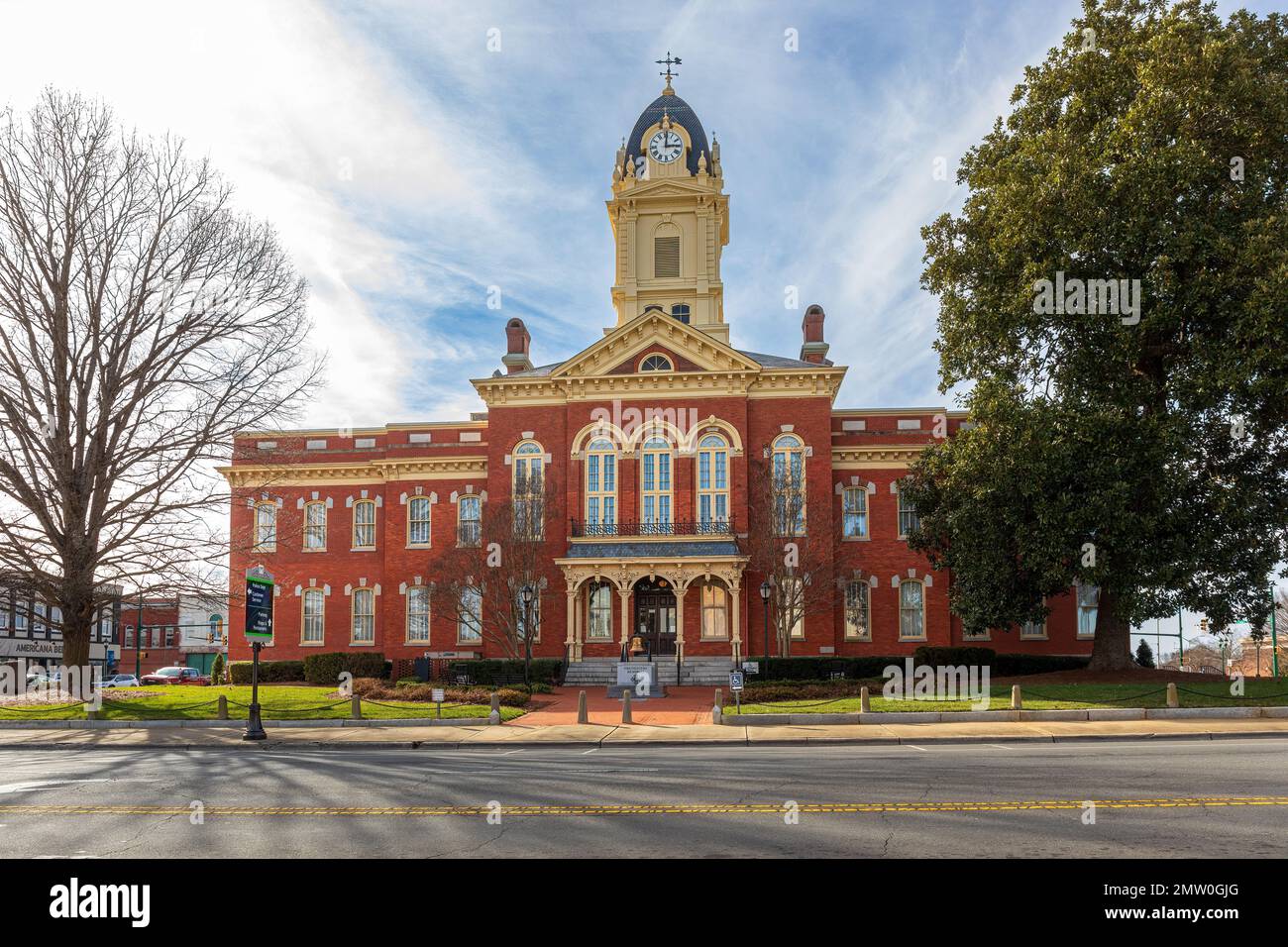 MONROE, NC, USA-28 GEN 2023: Storico 1886 tardo tribunale vittoriano, con immagine a specchio anteriore e posteriore, torre dell'orologio, cielo azzurro soleggiato. Foto Stock