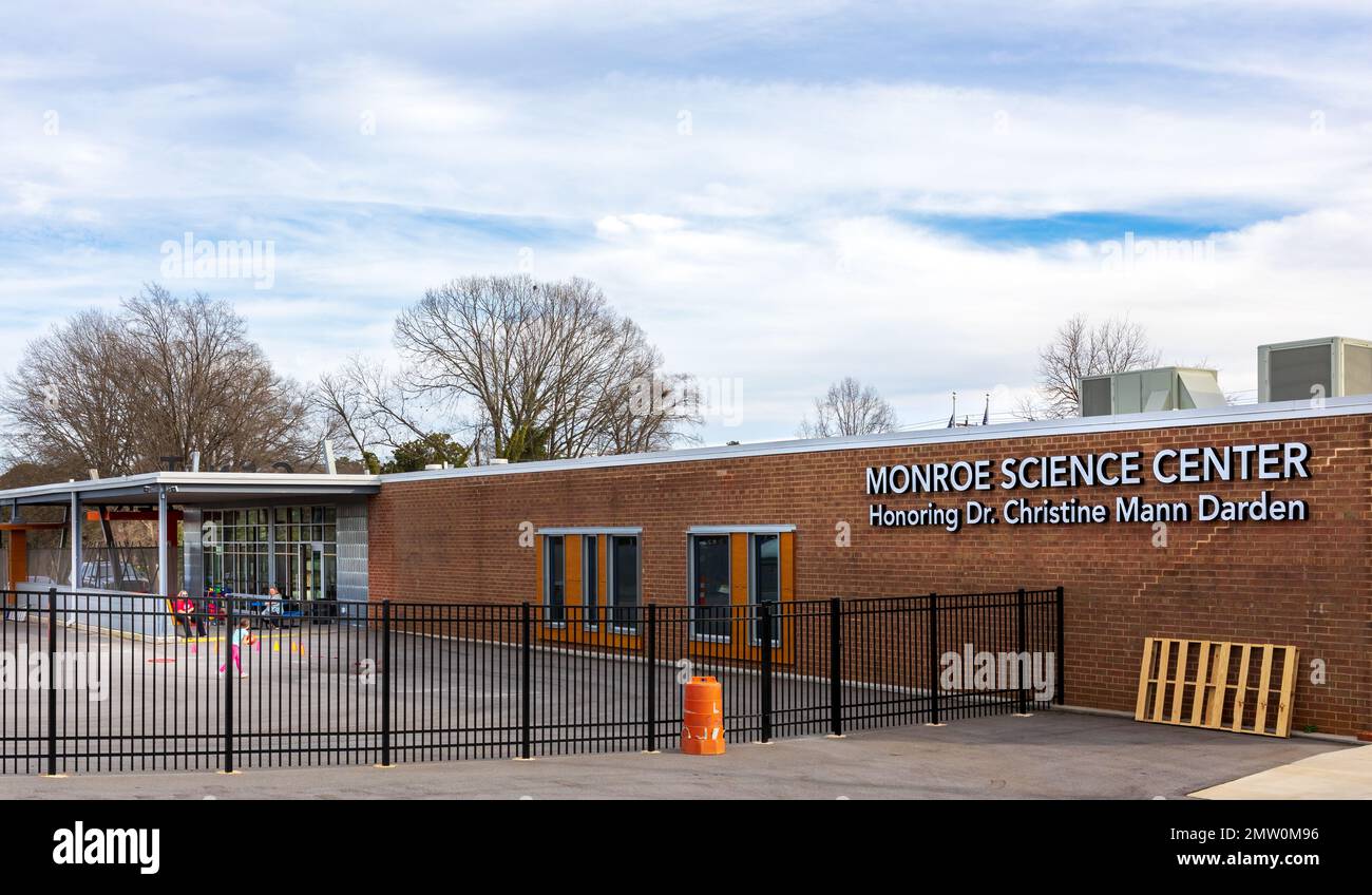 MONROE, NC, USA-28 GEN 2023: Monroe Science Center, retro dell'edificio con insegna e veranda coperta, adulti e bambini. Foto Stock