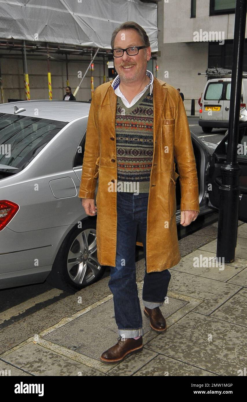 Il comico Jim Moir aka Vic Reeves è stato visto arrivare alla BBC  indossando un lungo cappotto di pelle marrone su un maglione grigio a motivi  geometrici, jeans blu e scarpe marroni.