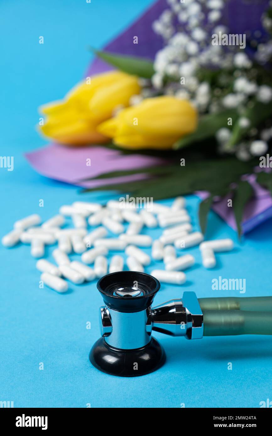 Giorno felice del medico o dell'infermiera, festa medica, scheda con i fiori, le pillole e lo stetoscopio Foto Stock