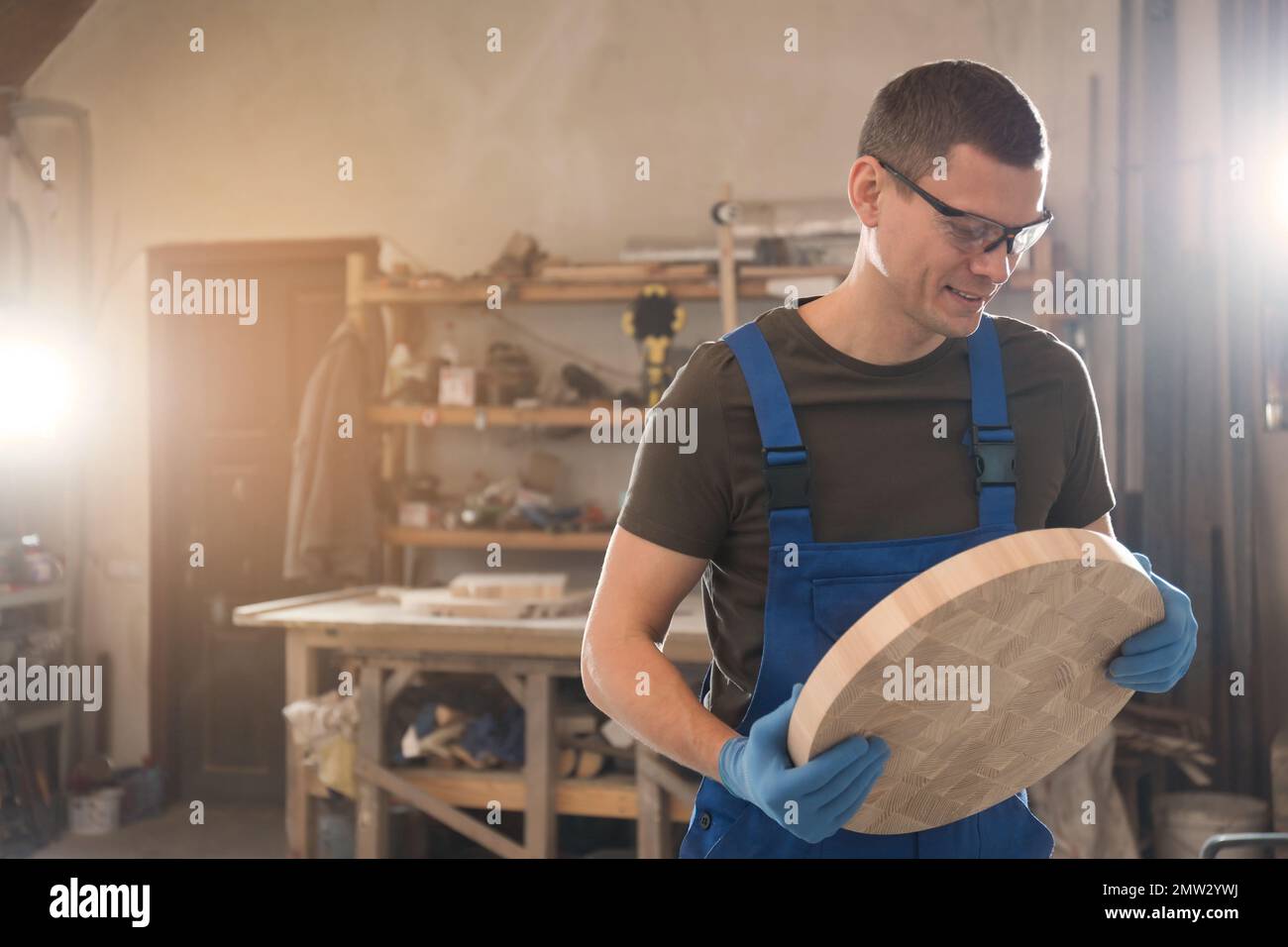 Falegname professionale con pezzo tondo di legno in officina Foto Stock