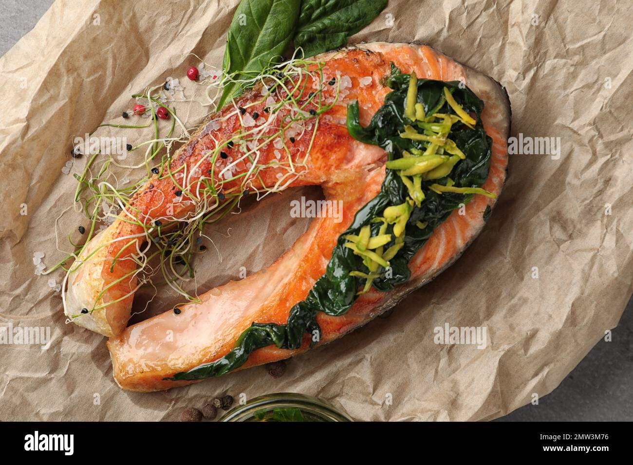 Salmone gustoso con spinaci su pergamena, primo piano Foto Stock