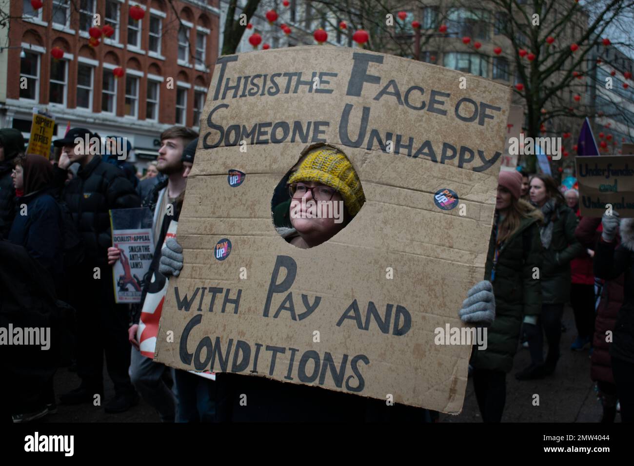 Proteggere il diritto alla protesta dello Sciopero, Manchester UK. Donna con segno di testo questo è il volto di qualcuno infelice con la paga e le condizioni Foto Stock