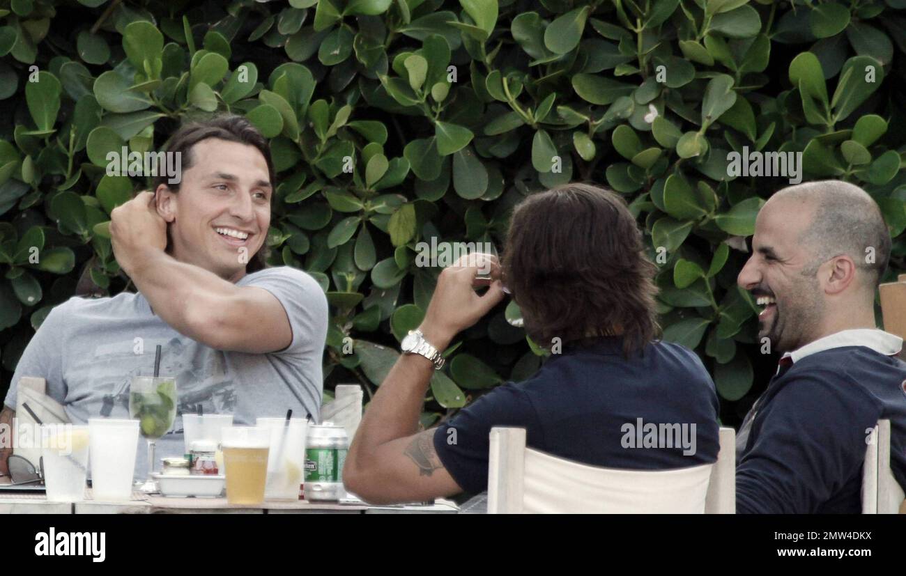 Uno dei calciatori più pagati, il calciatore svedese Zlatan Ibrahimovic, di 28 anni, ha un'ottima occasione di sedersi a bordo piscina con alcuni amici maschi. Rilassato Ibrahimovic, che è un attaccante per Barcellona e gioca con la nazionale svedese squadra, ha riso con i suoi amici ad un tavolo pieno di mojito e birra. Secondo le relazioni Ibrahimovic ha un salario di $11 milioni di dollari. Miami Beach, Florida. 07/08/10. Foto Stock