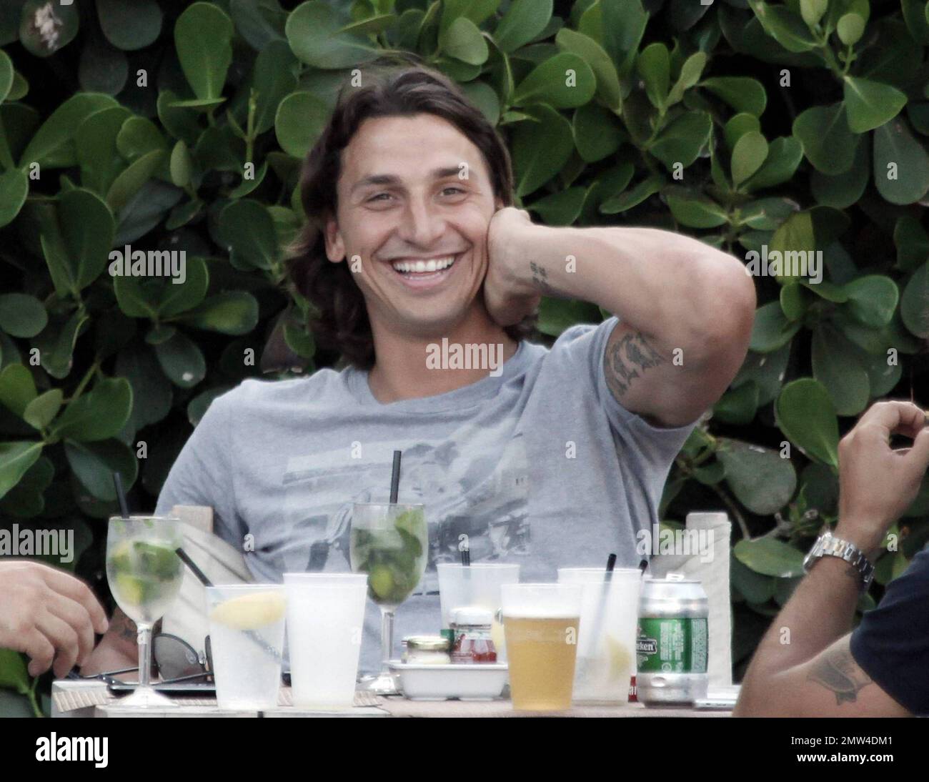Uno dei calciatori più pagati, il calciatore svedese Zlatan Ibrahimovic, di 28 anni, ha un'ottima occasione di sedersi a bordo piscina con alcuni amici maschi. Rilassato Ibrahimovic, che è un attaccante per Barcellona e gioca con la nazionale svedese squadra, ha riso con i suoi amici ad un tavolo pieno di mojito e birra. Secondo le relazioni Ibrahimovic ha un salario di $11 milioni di dollari. Miami Beach, Florida. 07/08/10. Foto Stock