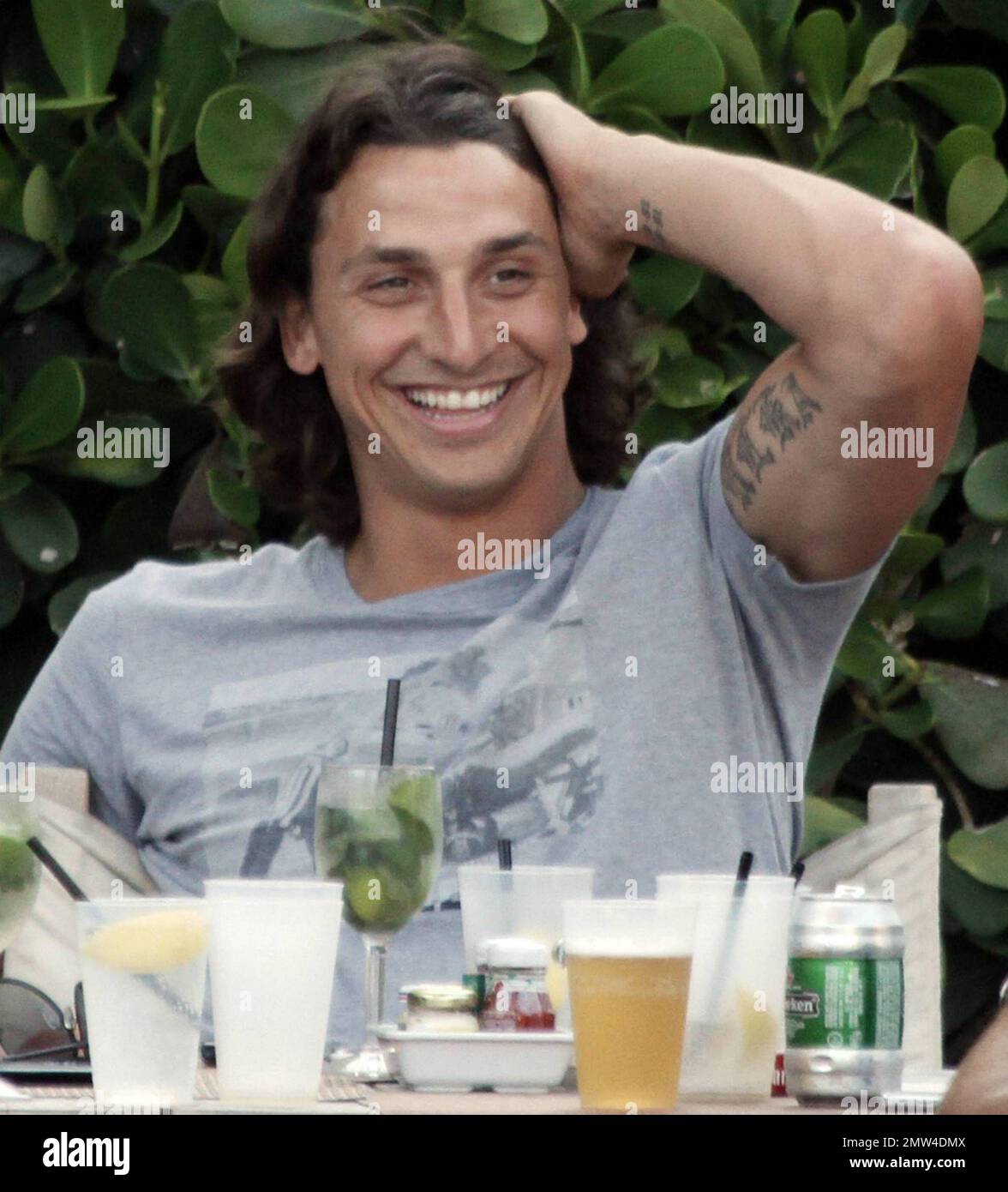 Uno dei calciatori più pagati, il calciatore svedese Zlatan Ibrahimovic, di 28 anni, ha un'ottima occasione di sedersi a bordo piscina con alcuni amici maschi. Rilassato Ibrahimovic, che è un attaccante per Barcellona e gioca con la nazionale svedese squadra, ha riso con i suoi amici ad un tavolo pieno di mojito e birra. Secondo le relazioni Ibrahimovic ha un salario di $11 milioni di dollari. Miami Beach, Florida. 07/08/10. Foto Stock