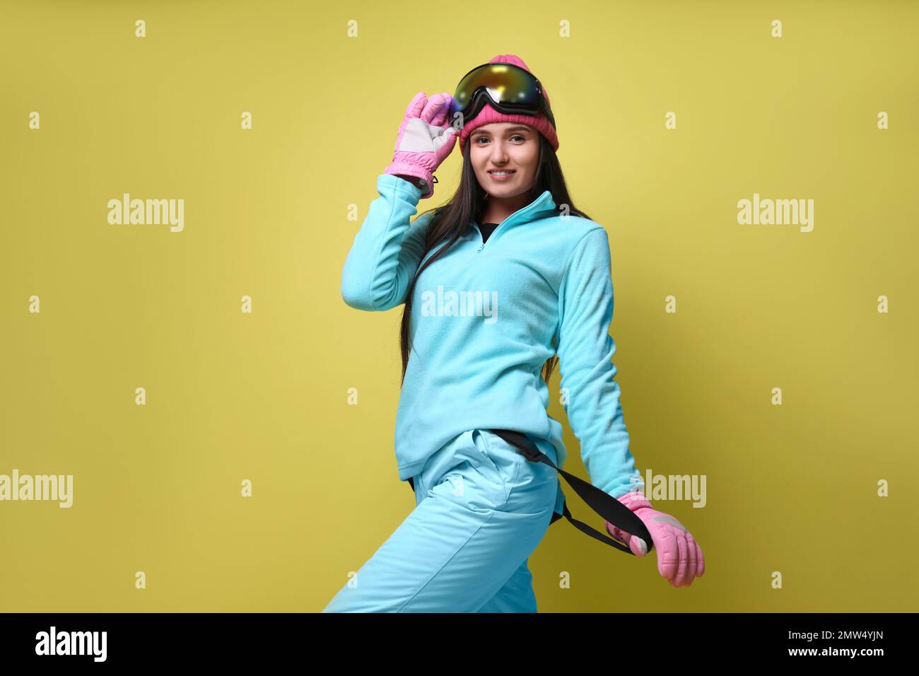 Donna che indossa abiti sportivi invernali eleganti su sfondo giallo, vista  a basso angolo Foto stock - Alamy