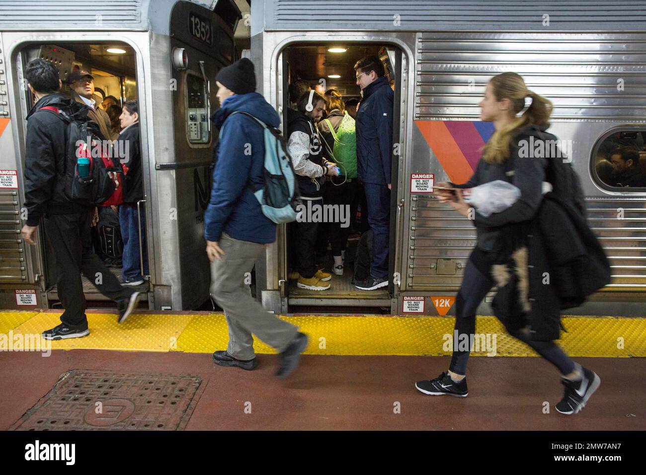 Evening rush hour commuters walk to board their New Jersey Transit train at Penn Station, Friday, March 24, 2017, in New York. Commuters to both New Jersey and Long Island faced a difficult journey home Friday evening after two passenger trains clipped each other during the morning rush at Penn Station, jolting riders and creating major travel disruptions, but causing no serious injuries. (AP Photo/Mary Altaffer) Foto Stock