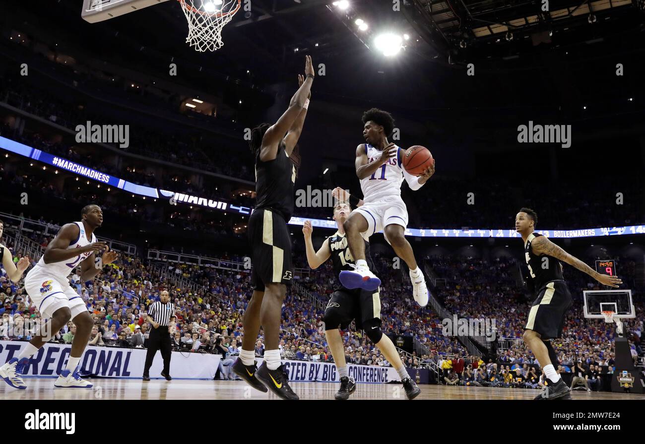 Kansas guard Josh Jackson (11) drives to the basket ahead of Purdue's Caleb Swanigan, left, and Ryan Cline (14) during the first half of a regional semifinal of the NCAA men's college basketball tournament, Thursday, March 23, 2017, in Kansas City, Mo. (AP Photo/Charlie Riedel) Foto Stock