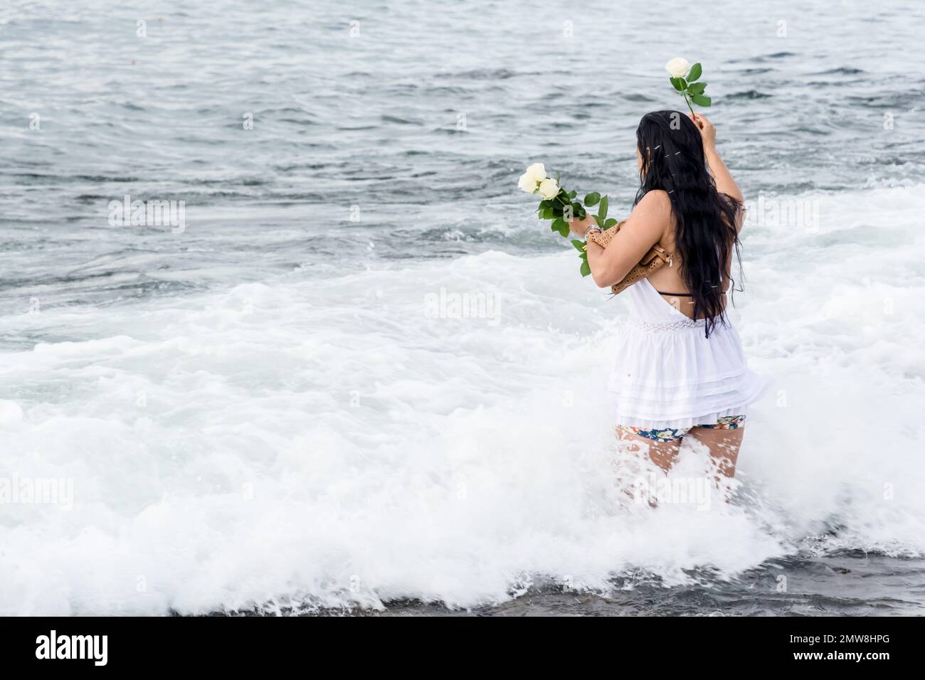 Salvador, Bahia, Brasile - 02 febbraio 2017: Una donna che ammira Candomble getta fiori in mare in onore di Iemanja il giorno della sua festa. Salvador, Foto Stock