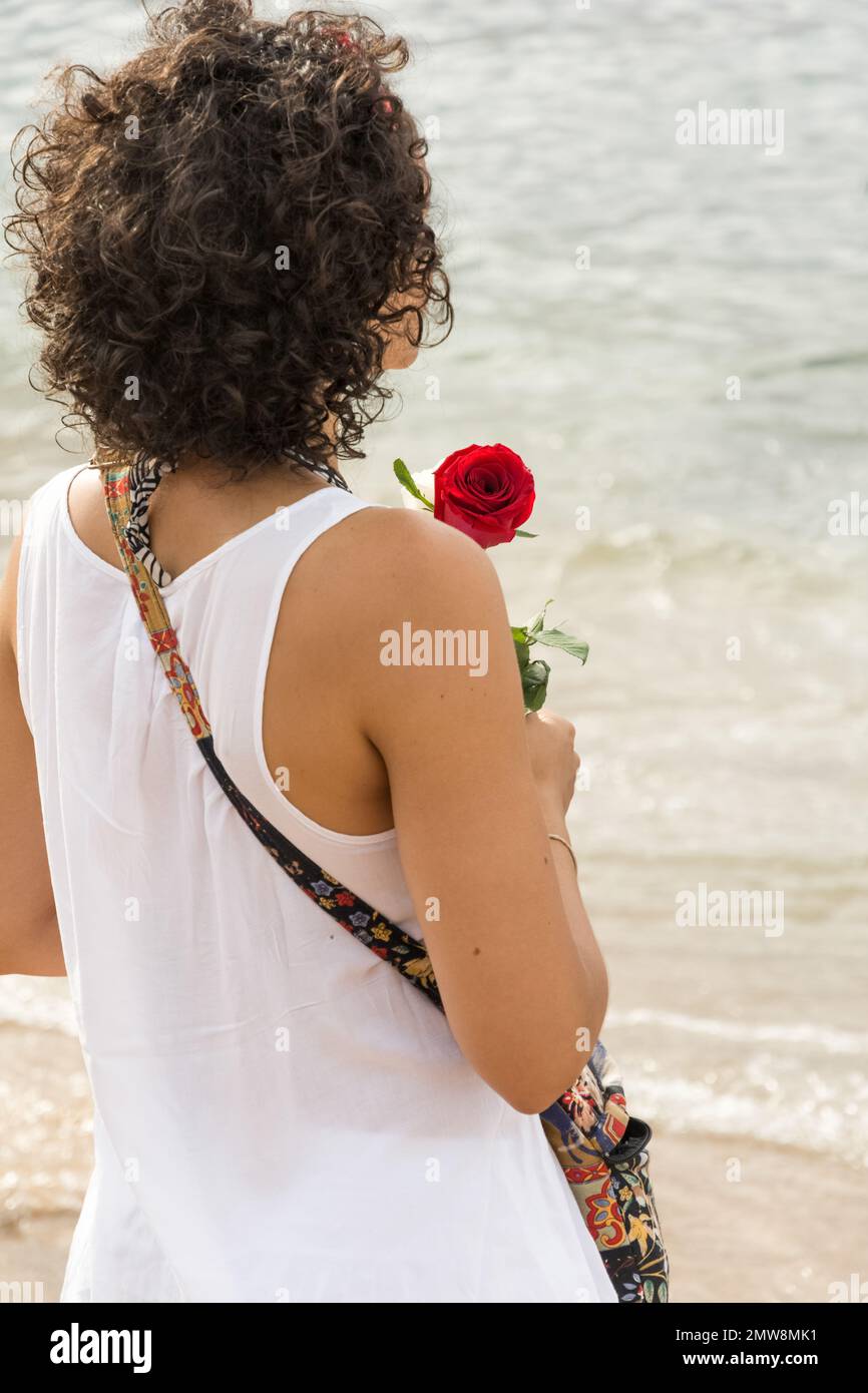 Salvador, Bahia, Brasile - 02 febbraio 2017: Una donna che ammira Candomble getta fiori in mare in onore di Iemanja il giorno della sua festa. Salvador, Foto Stock