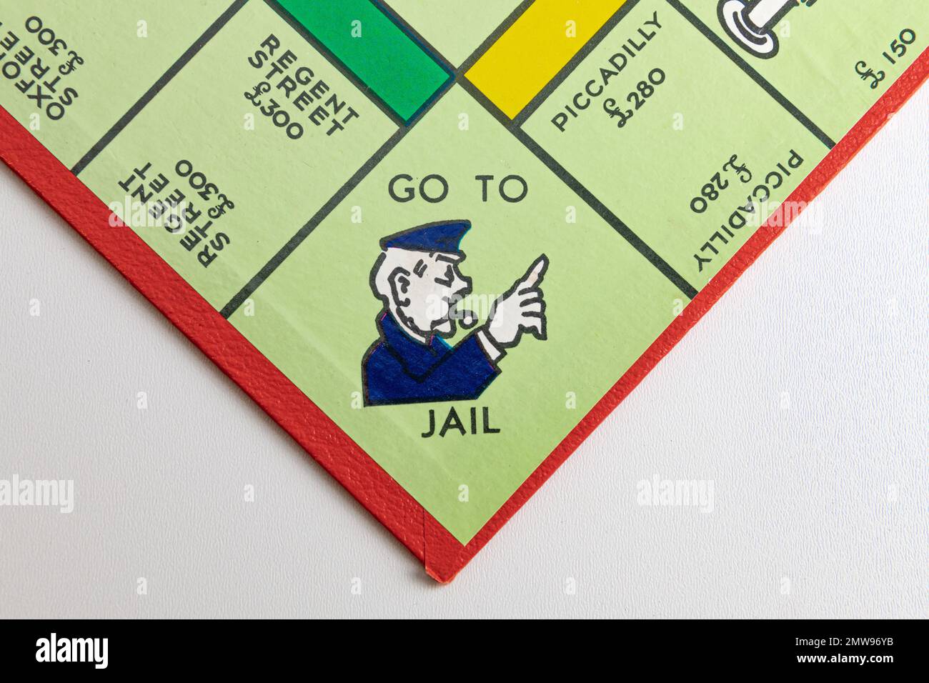 The Go to Jail Square su un consiglio di amministrazione del monopolio britannico su uno sfondo bianco Foto Stock