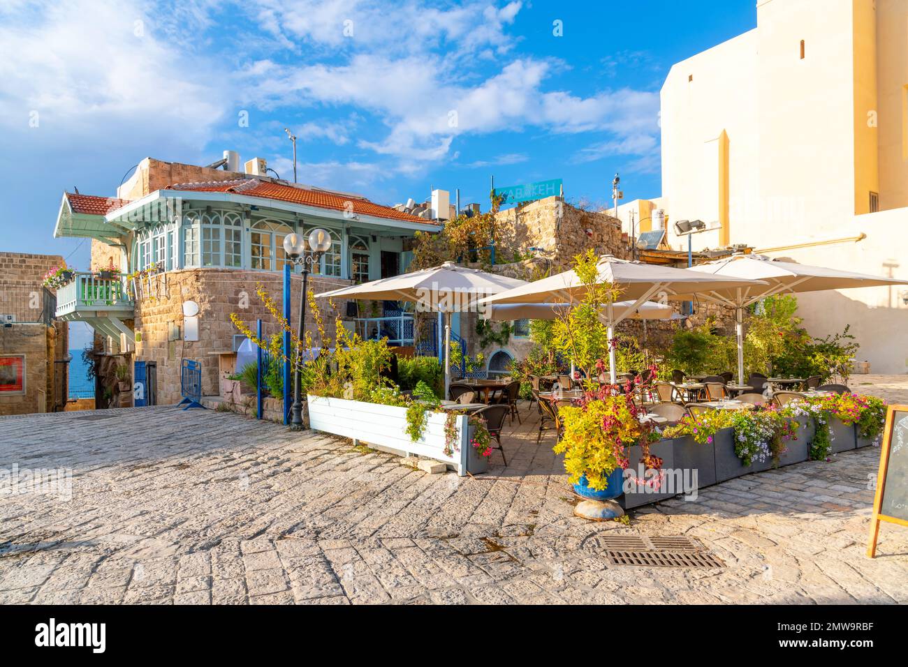 Una caffetteria colorata con posti a sedere all'aperto in Piazza Kedumim (Kikar Kdumim), nella città vecchia ottomana medievale di Jaffa, Israele. Foto Stock