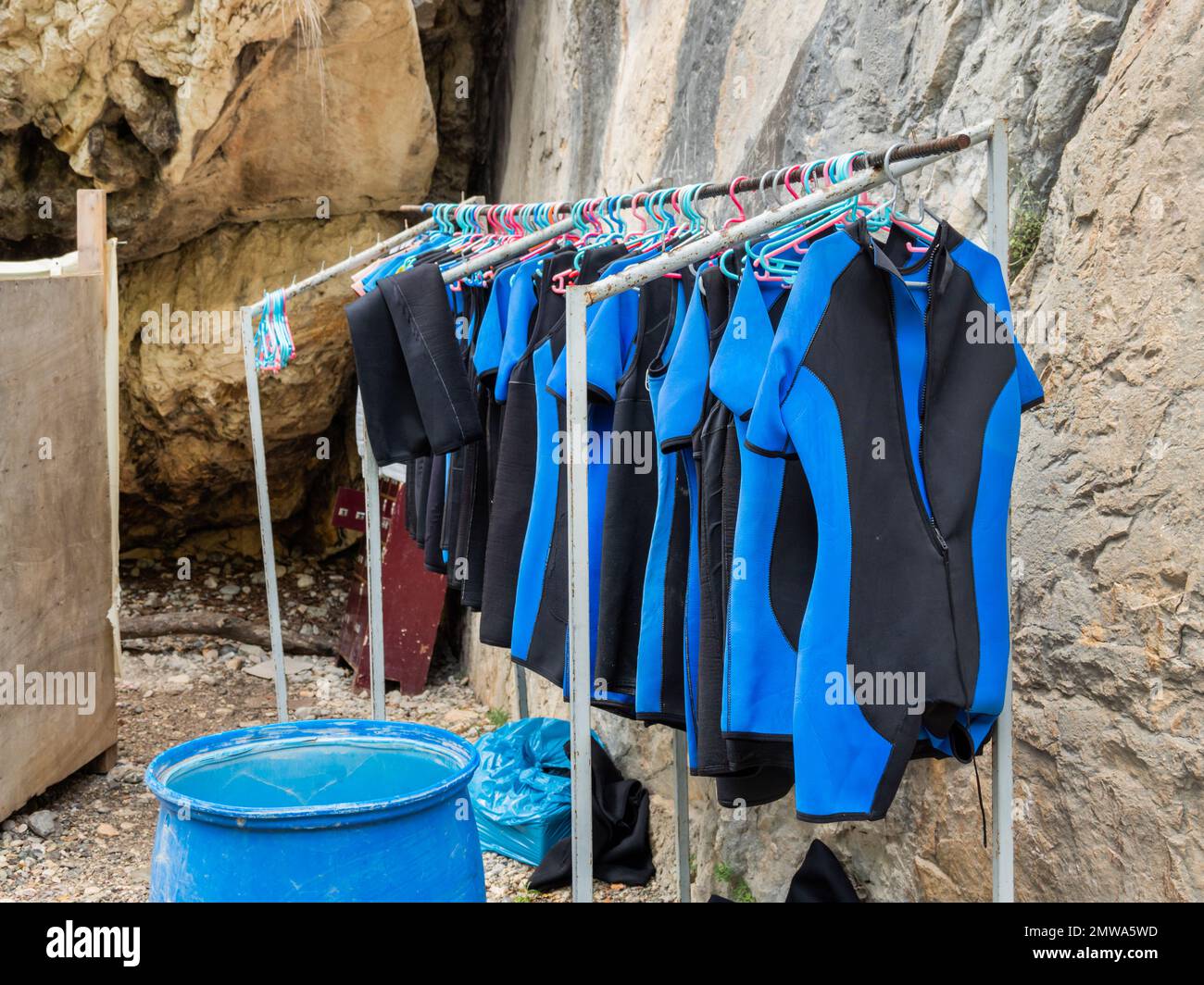 Mute blu su appendiabiti. Tute da immersione per sportivi. Attrezzature sportive per turisti. Escursione sul lago di montagna. Foto Stock