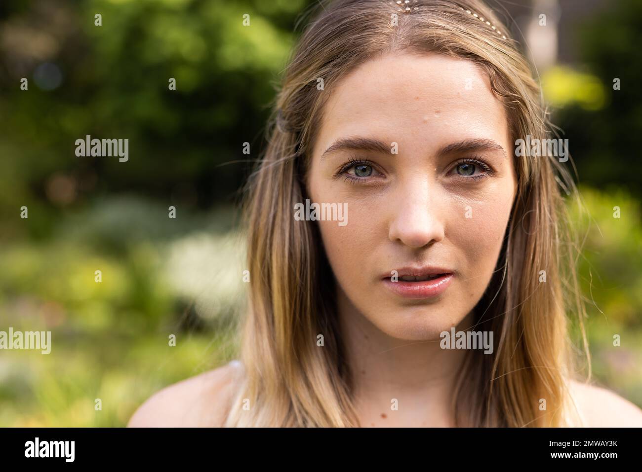 Ritratto di sposa caucasica con occhi verdi in giardino al matrimonio all'aperto, con spazio copia Foto Stock