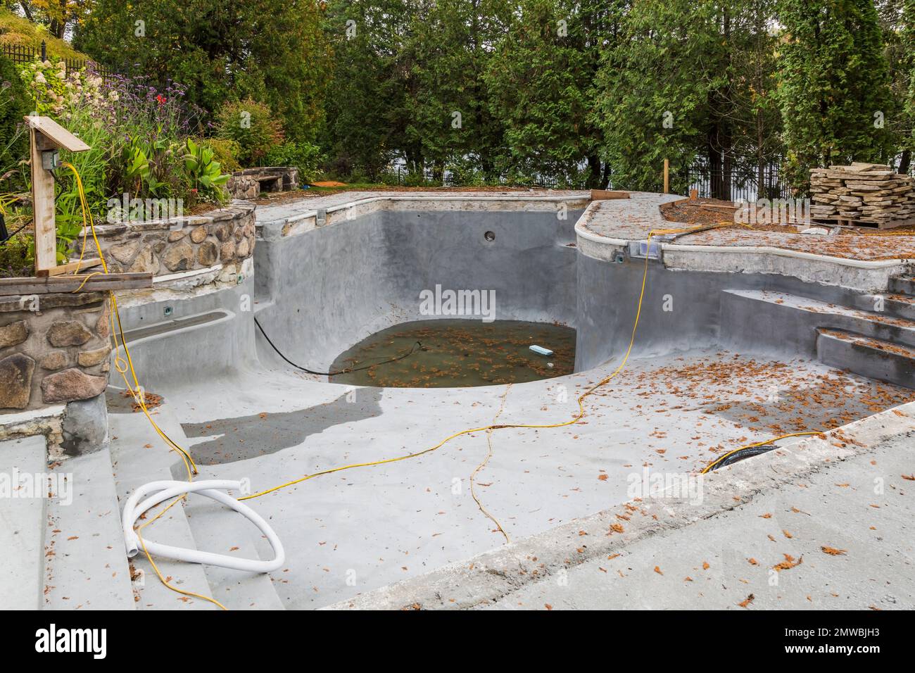 Costruzione di cemento nella piscina coperta nel cortile posteriore in autunno. Foto Stock