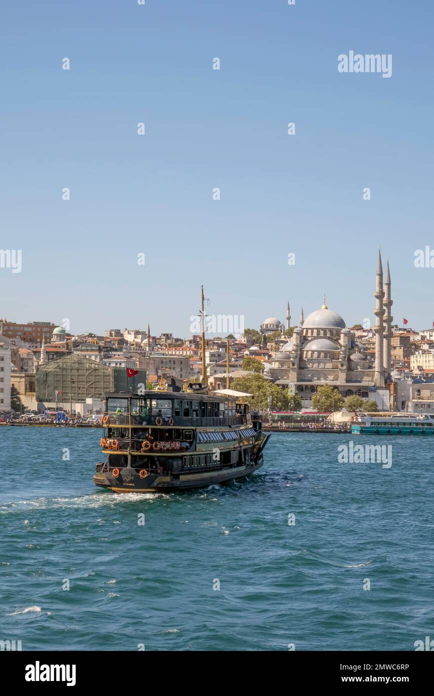 Un primo piano verticale di una nave nera sul Bosforo contro il paesaggio urbano di Istanbul Foto Stock