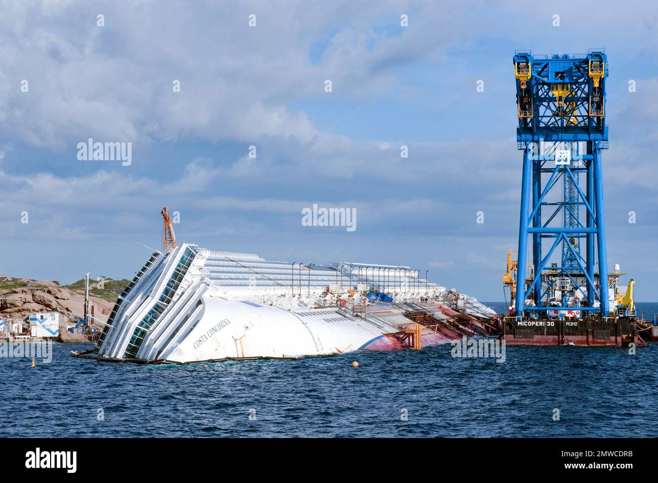 Vista della prua di una nave da crociera con il nome Costa Concordia visibile, accanto ad essa una gru di salvataggio, Giglio Porto, Isola del Giglio, Toscana Foto Stock