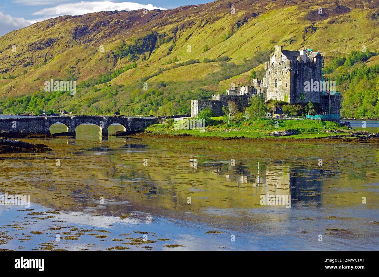 Castello riflesso in acqua, ponte e montagne, Eilean Donan Castello, Highlands, Dornie, Scozia, Gran Bretagna Foto Stock