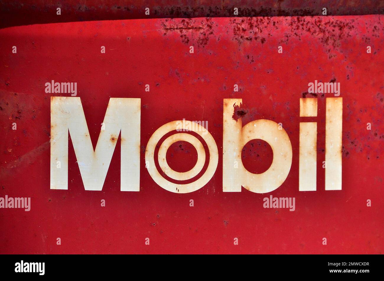 Iscrizione su un barile di olio rosso arrugginito di Mobil Foto Stock