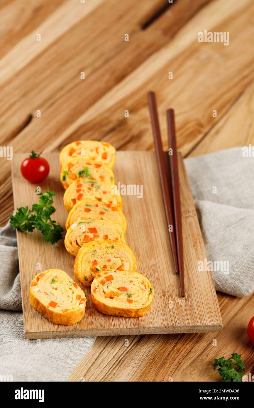 Telur Dadar Gulung. Tamagoyaki o Japanses Egg Roll. Gyeran Mari, meletta coreana arrotolata con carota e cipolla primaverile Foto Stock