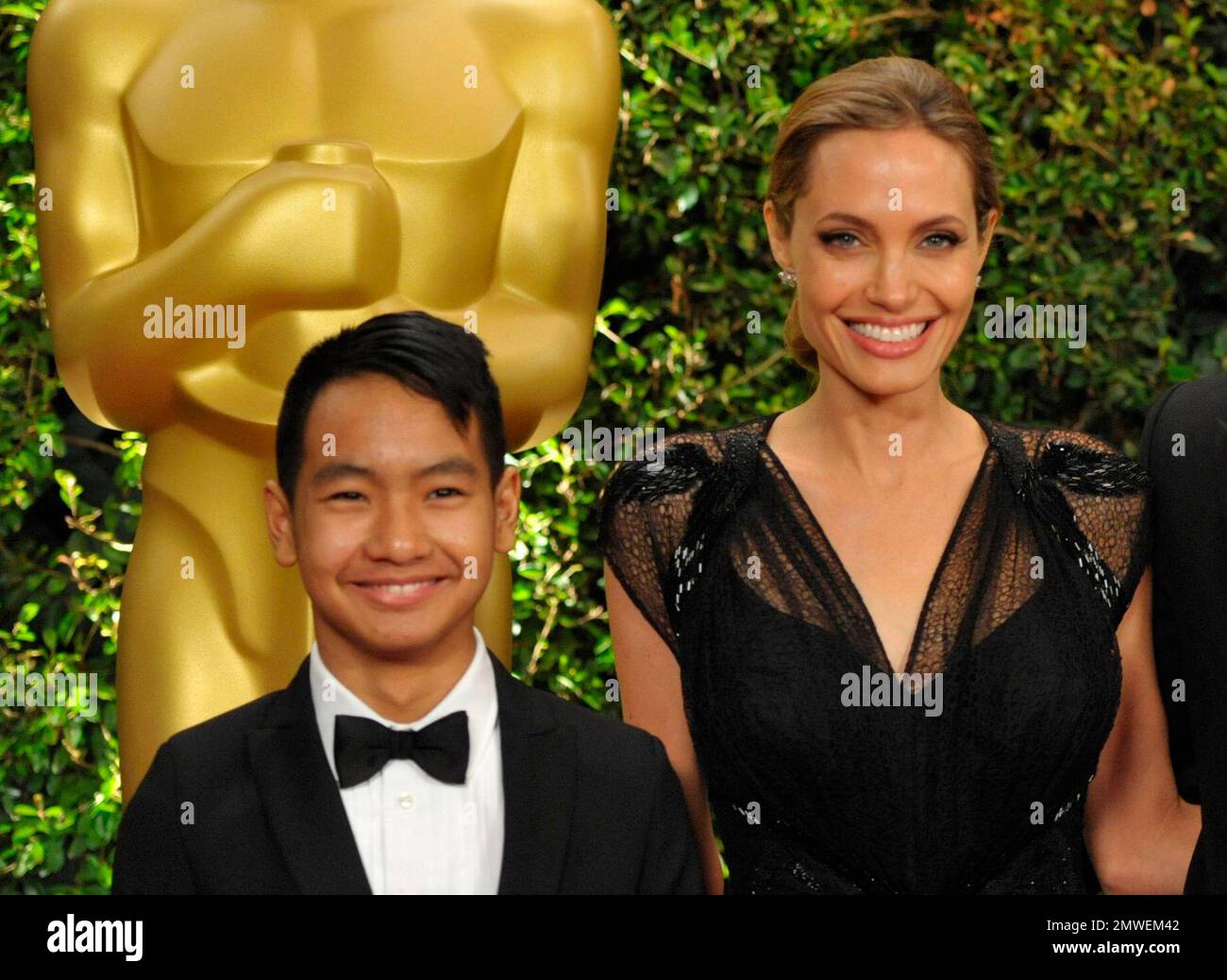FILE - This Nov. 16, 2013 file photo shows Maddox Jolie-Pitt, with Angelina Jolie on the red carpet at the 2013 Board of Governors of the Academy of Motion Picture Arts and Sciences' Governor Awards, in Los Angeles. Cambodia's King Norodom Sihamoni will preside over the premiere of Angelina Jolie's film based on a memoir from a Khmer Rouge survivor. Queen Mother Norodom Monineath Sihanouk will also attend the showing of "First They Killed My Father," on Saturday at the centuries-old Angkor Wat temple complex, an official said. Jolie directed the Khmer-language film on location in 2015-16. (Pho Foto Stock
