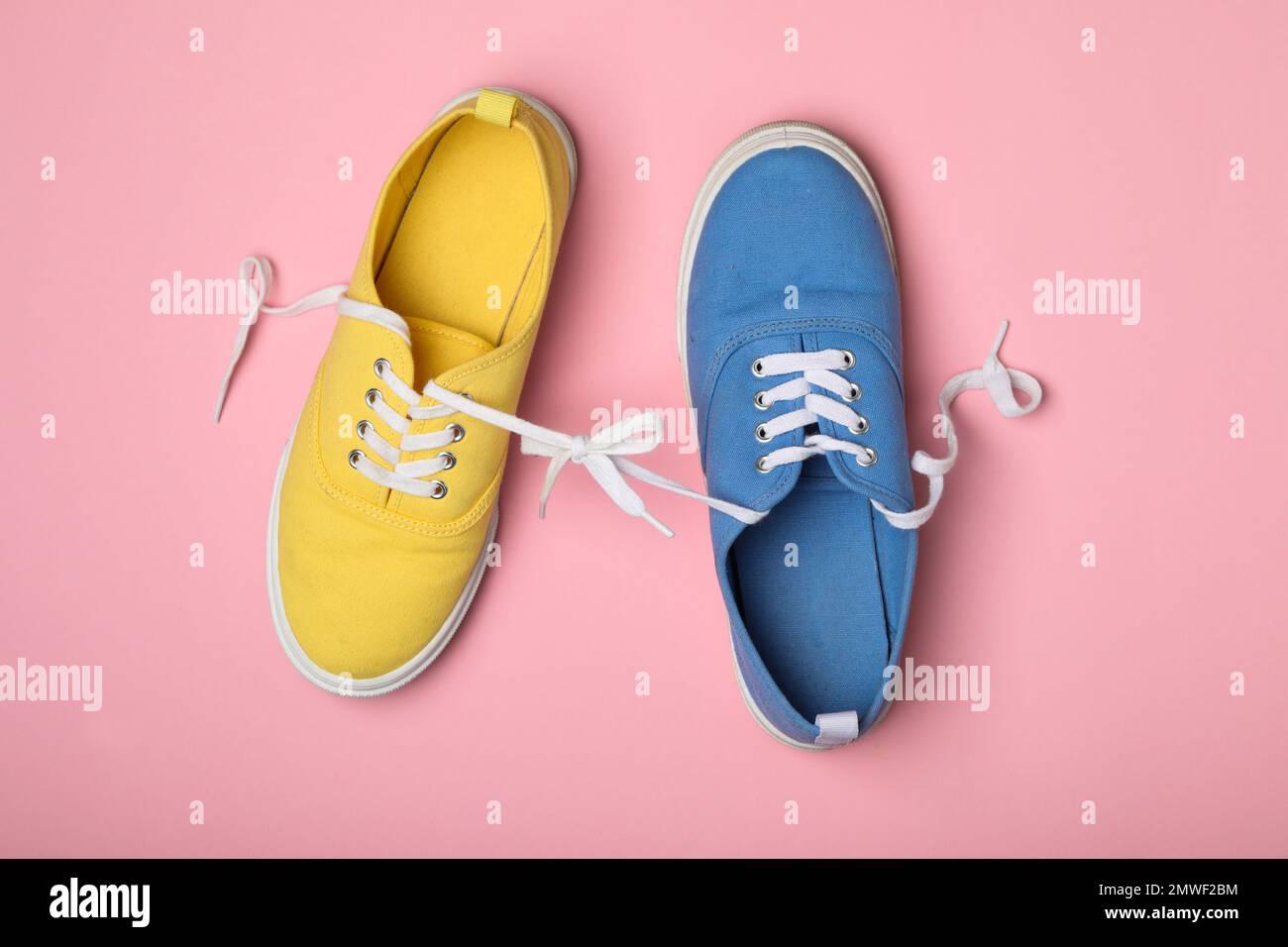 Scarpe legate insieme su sfondo rosa, piatto. Fool's Day di aprile Foto Stock