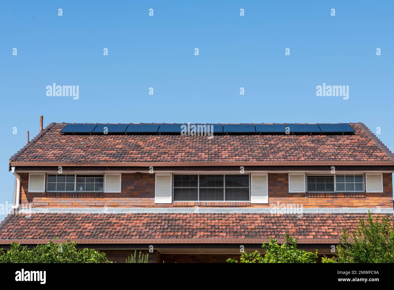 Energia rinnovabile pulita verde risparmio energetico efficiente pannelli solari fotovoltaici sul tetto piastrellato di casa, con spazio copia e cielo blu Foto Stock