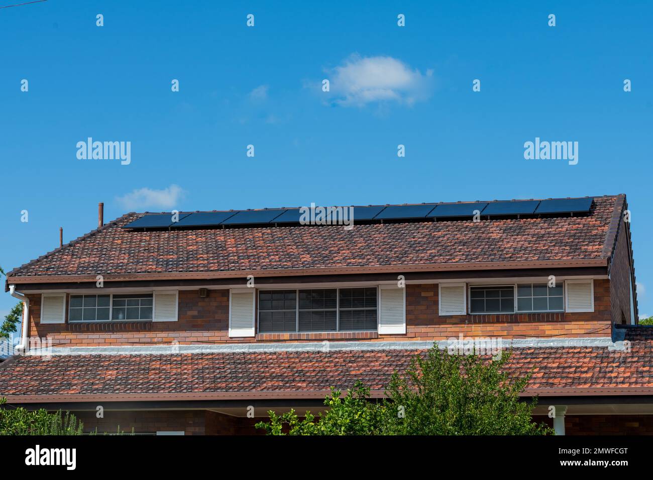 Energia rinnovabile pulita verde risparmio energetico efficiente pannelli solari fotovoltaici sul tetto piastrellato di casa, con spazio copia e cielo blu Foto Stock