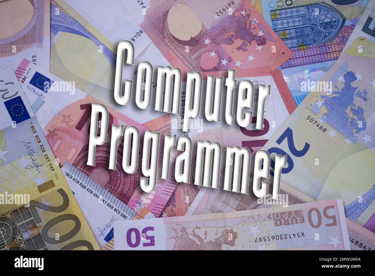 Programmatore di computer parola con soldi. Sfondo di valuta cartacea con banconote diverse. Foto Stock