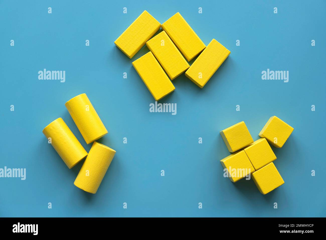 Concetto di categoria. La forma diversa del blocco di geometria in legno giallo si riorganizza nella sua categoria. Foto Stock