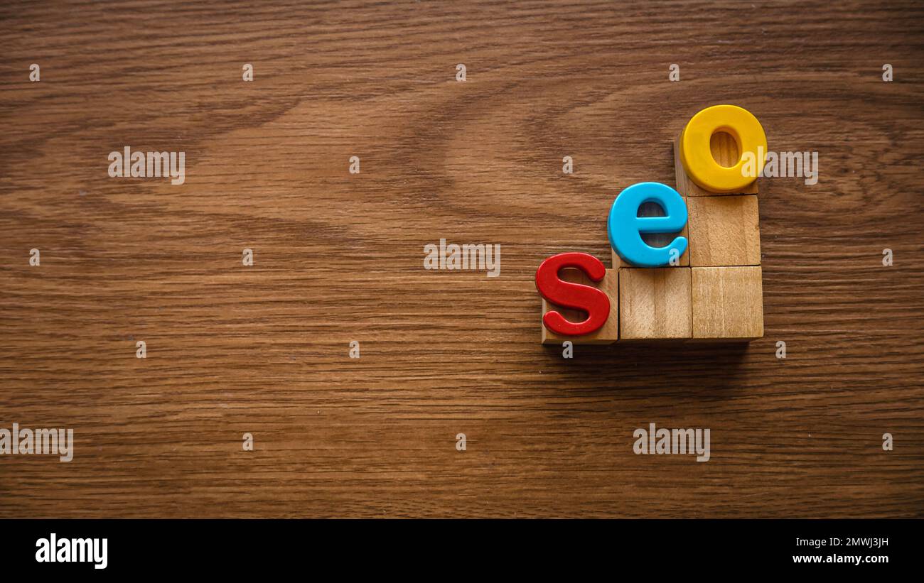 Concetto di ottimizzazione dei motori di ricerca. Alfabeto di seo su una scala di cubo di legno. Foto Stock